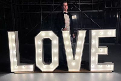 Lichtletters huren Je ziet de lichtletters ''LOVE'' met een jongen in gala pak